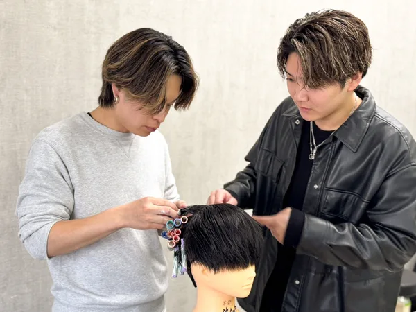 先輩スタイリストが施術を指導している様子